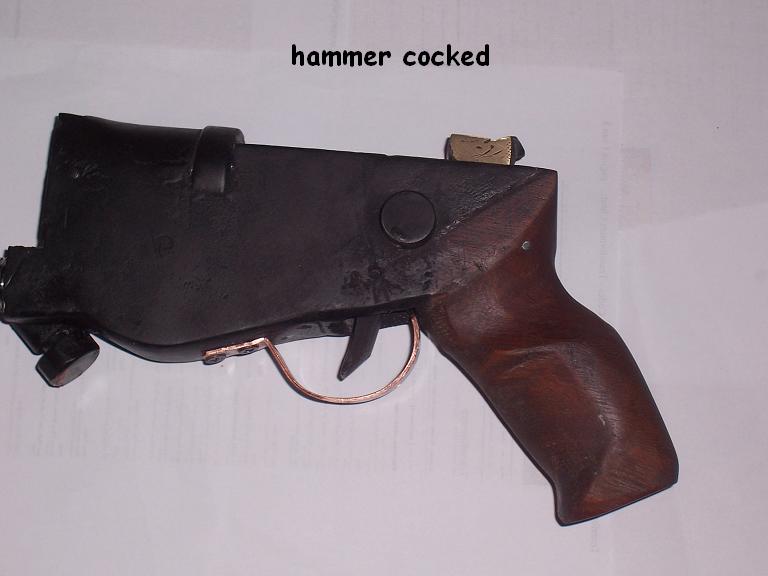 With the cocked hammer.I seem to have misplaced the picture of it when in rest.Anyway, it;s easy to cock with just my thumb, and the trigger is extremely smooth.