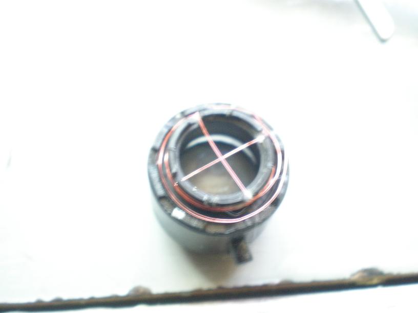 The plastic piece holding my lens already had 4 grooves in it, I just crossed the wire and wrapped it around the outside to hold it in place, glue might be necessary to secure the wire.