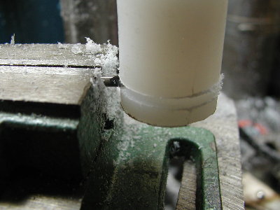 The tool is secured in a drill press vise and the vise is moved into the side of the piston.  The groove is first cut too narrow and too shallow.  It is easier to make it larger later than to make it smaller.