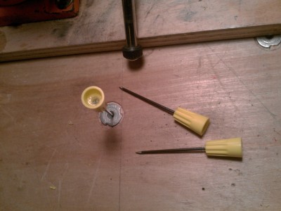 drill a hole in the closed side, making sure to retain that inner wire coil, pound a nail through, add a bit o' poxy.  The epoxy grabs that wire coil nicely and secures the nail head in place.