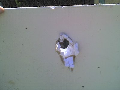 Exit hole in sheet rock made by bar-bell.