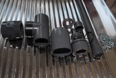 The line-up. Threaded 1&amp;quot; coupler, tee, coupler to go over tee to extend it, and (bottom to top) pilot valve seat, opener (central) piston, and exit port piston and seat. To the right is the uncompleted bolt.<br />The o-ring is for the opener piston.