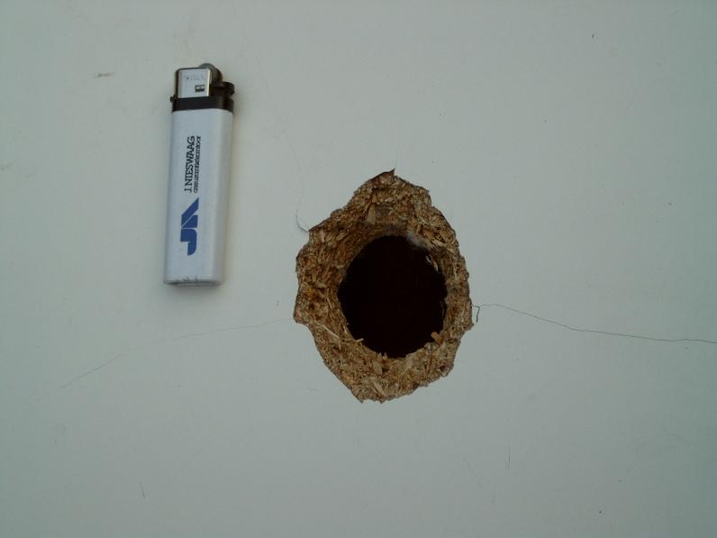 And ofcourse the exithole is bigger.Lighter is a size referance.Overkill is a pneumatic, not a combustion gun.<br />The damage is at around 200 psi.It could probably have shot though more layers.Imagine what 300 psi does...Notice the board has a crack in it..The impact actually broke the entire back of the board