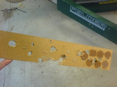 spud- wax-and epoxy-slugs shot at a sheet of thin chipboard-like material at different pressures