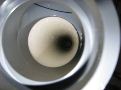 Down the barrel, from the breech.